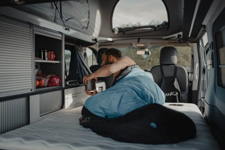 homme allongé dans un van aménagé