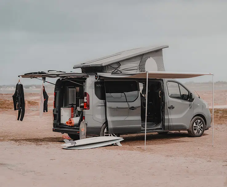 vue de profil van aménagé hanroad sur porteur renault trafic avec store fiamma et toit relevé