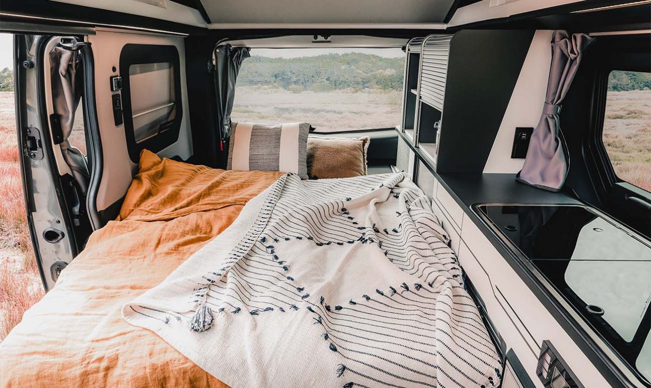 banquette convertible en lit van aménagé hanroad avec couvertures et coussins