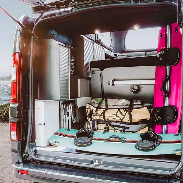 grand coffre d'un van aménagé avec table intégrée et kite surf stocké hanroad