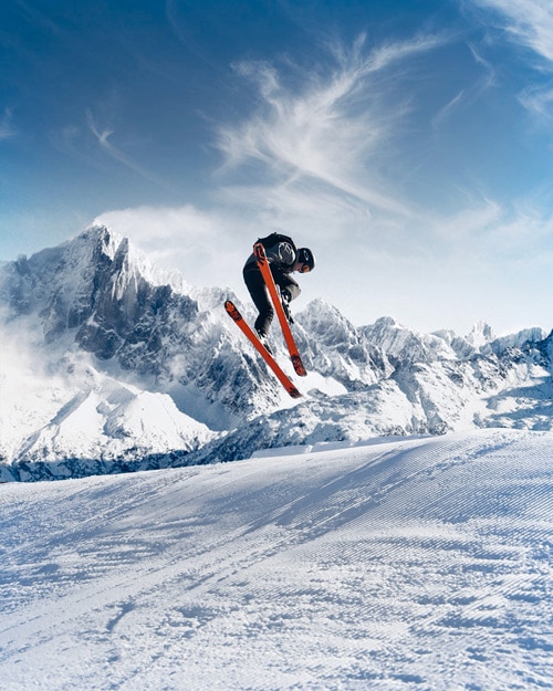 skieur faisant un saut au dessus de la neige