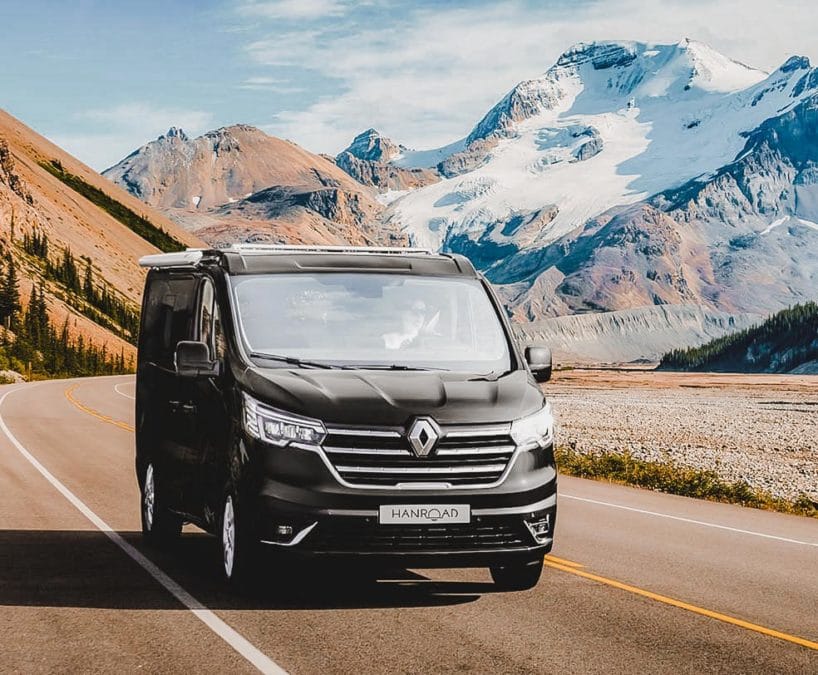 van aménagé de couleur noir hanroad sur porteur renault trafic roulant sur une route de montagne