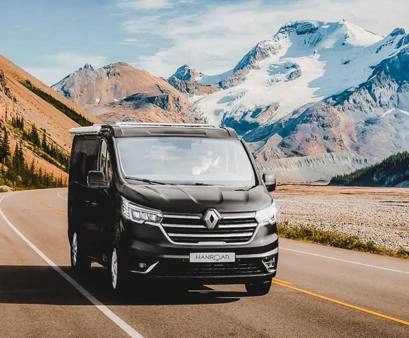 van aménagé de couleur noir hanroad sur porteur renault trafic roulant sur une route de montagne