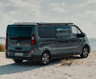 van aménagé hanroad sur porteur renault trafic L2 avec store fiamma garé sur le sable face à la mer