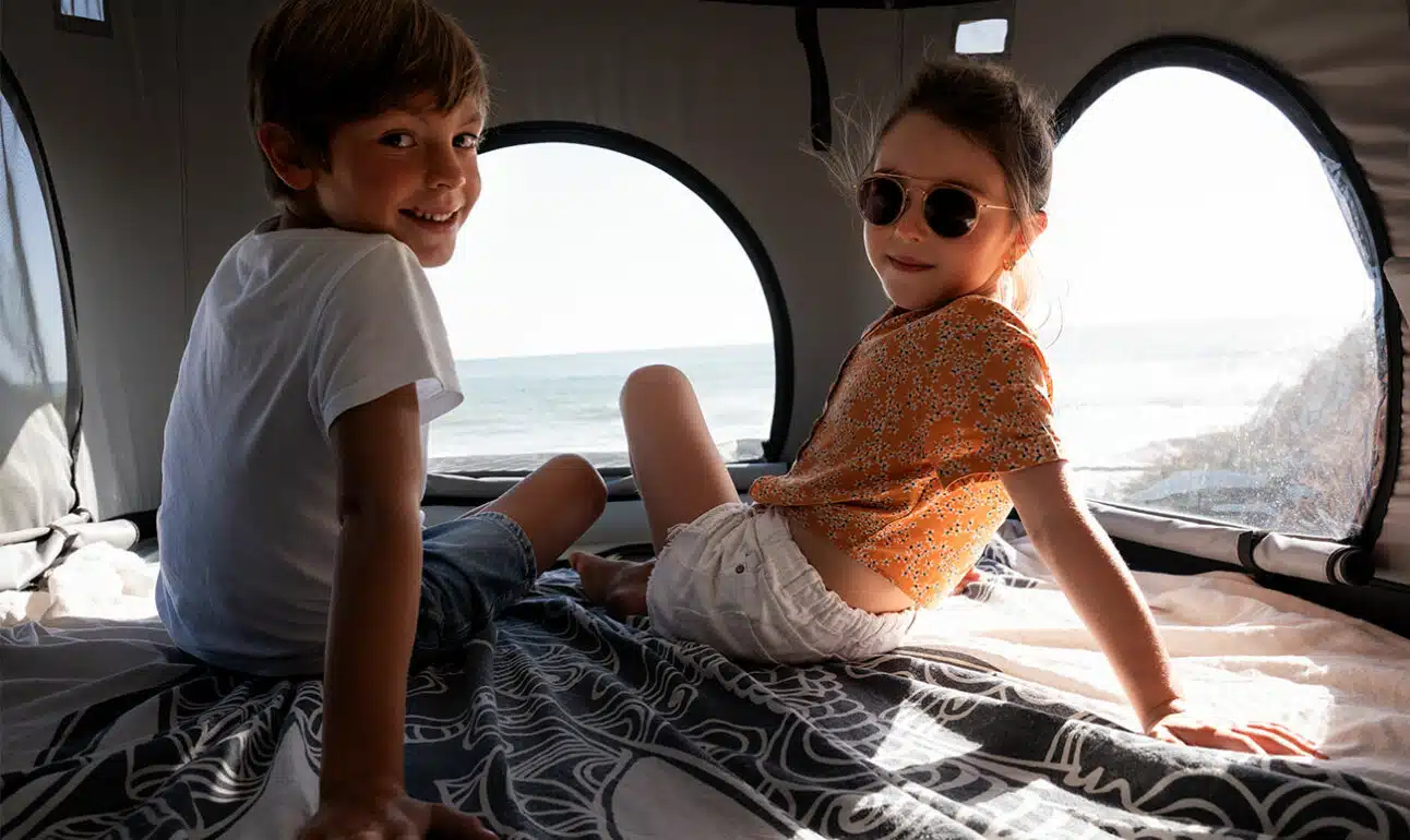 deux enfants assis dans un toit relevable d'un van aménagé hanroad