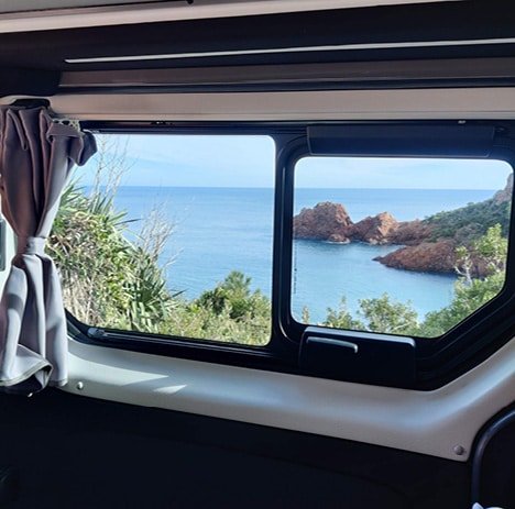 vue sur la mer depuis la fenêtre d'un van aménagé hanroad 