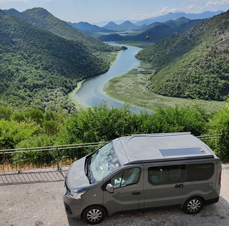 van aménagé hanroad passant sur un pont au dessous d'une belle rivière