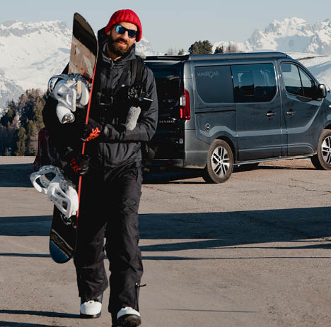 snowboarder devant un van aménagé au ski