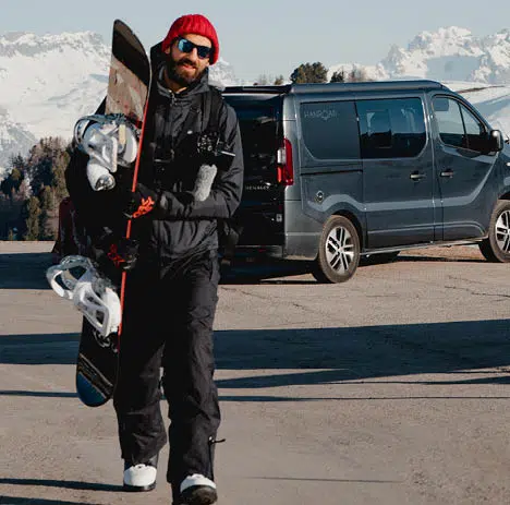 snowboarder devant un van aménagé au ski
