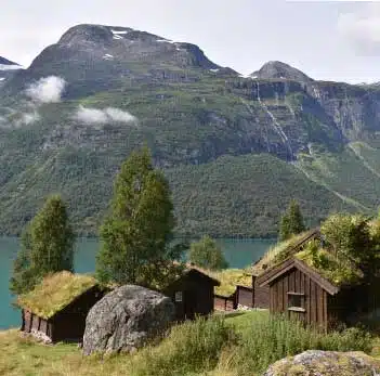 maisons en bois en bord de fjord norvégien avec vue sur la montagne