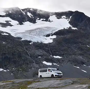 van aménagé blanc hanroad garé en bas d'une montagne enneigée en norvège