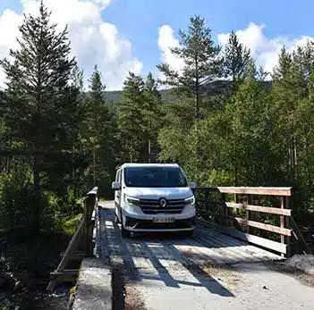 van aménagé hanroad passant un petit pont en bois en norvège