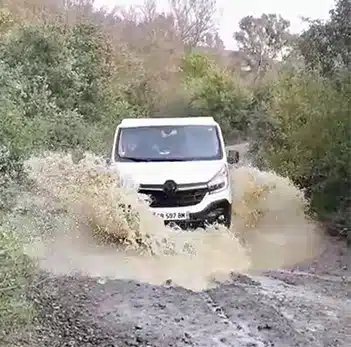 un van aménagé hanroad tout terrain traversant un cours d'eau