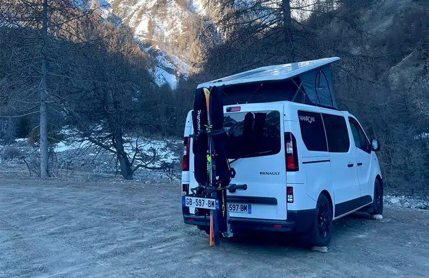 van aménagé hanroad à toit relevable avec des skis attachés à l'arrière