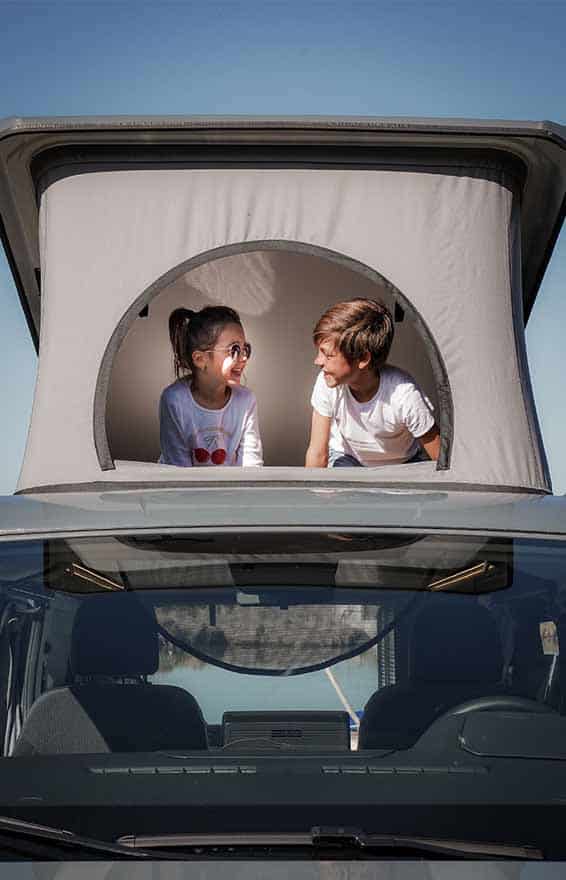 toit relevable vue de face d'un van aménagé hanroad avec deux enfants à l''intérieur
