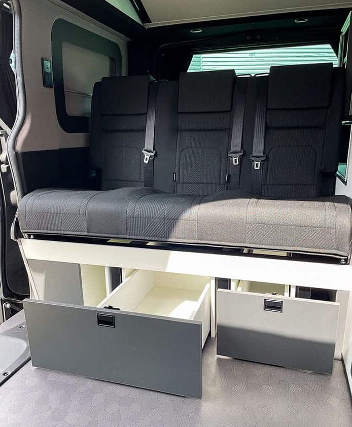 Van aménagé : Banquette fixe avec les deux tiroirs ouverts.
