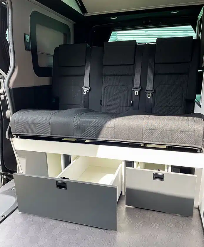 Van aménagé : Banquette fixe avec les deux tiroirs ouverts.