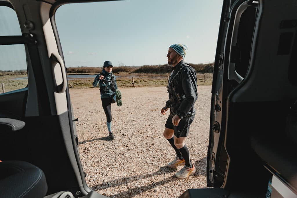 Couple de traileur qui s'échauffe avant sa sortie devant son van aménagé Hanroad.