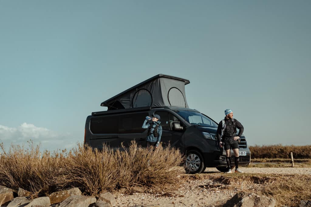 Couple de sportif devant leur van aménagé Hanroad sur porteur Renault trafic.