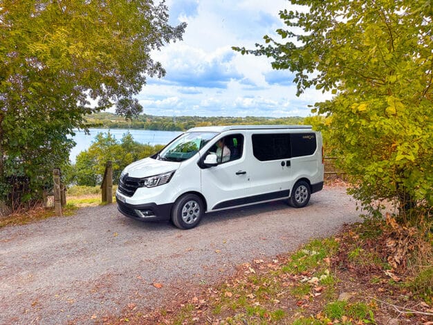 van aménagé blanc hanroad entouré d'arbres