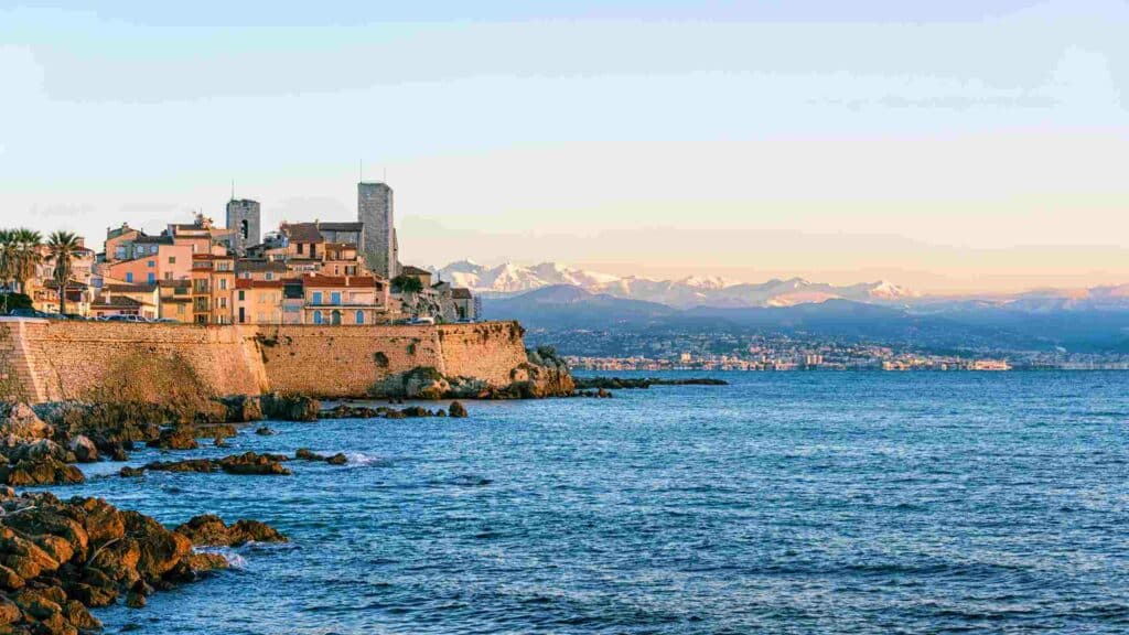 ville d'antibes en bord de mer avec la montagne enneigé