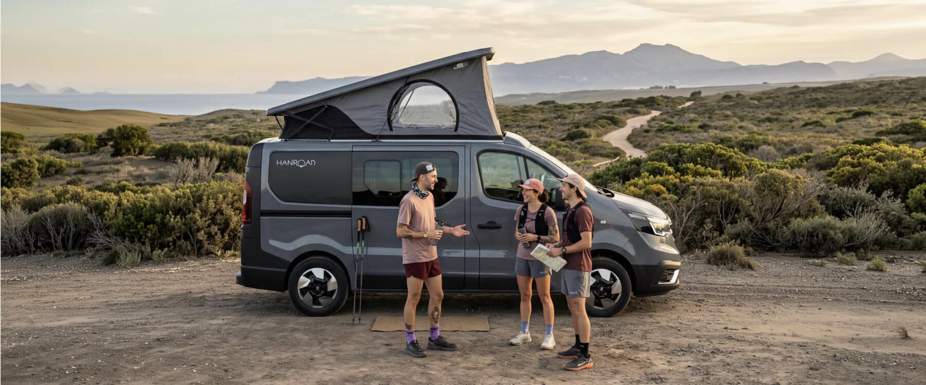 personnes faisant du trail devant un van aménagé à toit relevé hanroad